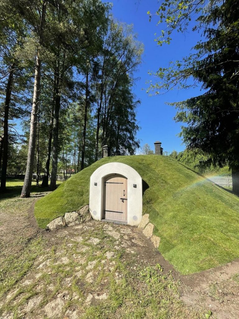 Kaasaegne maaalune kelder muruga kaetud küngas ja puidust uks, sobib looduslähedaseks hoiustamiseks - Saku Ehitus maa-aluste keldrite ehitus ja maastikukujundus.